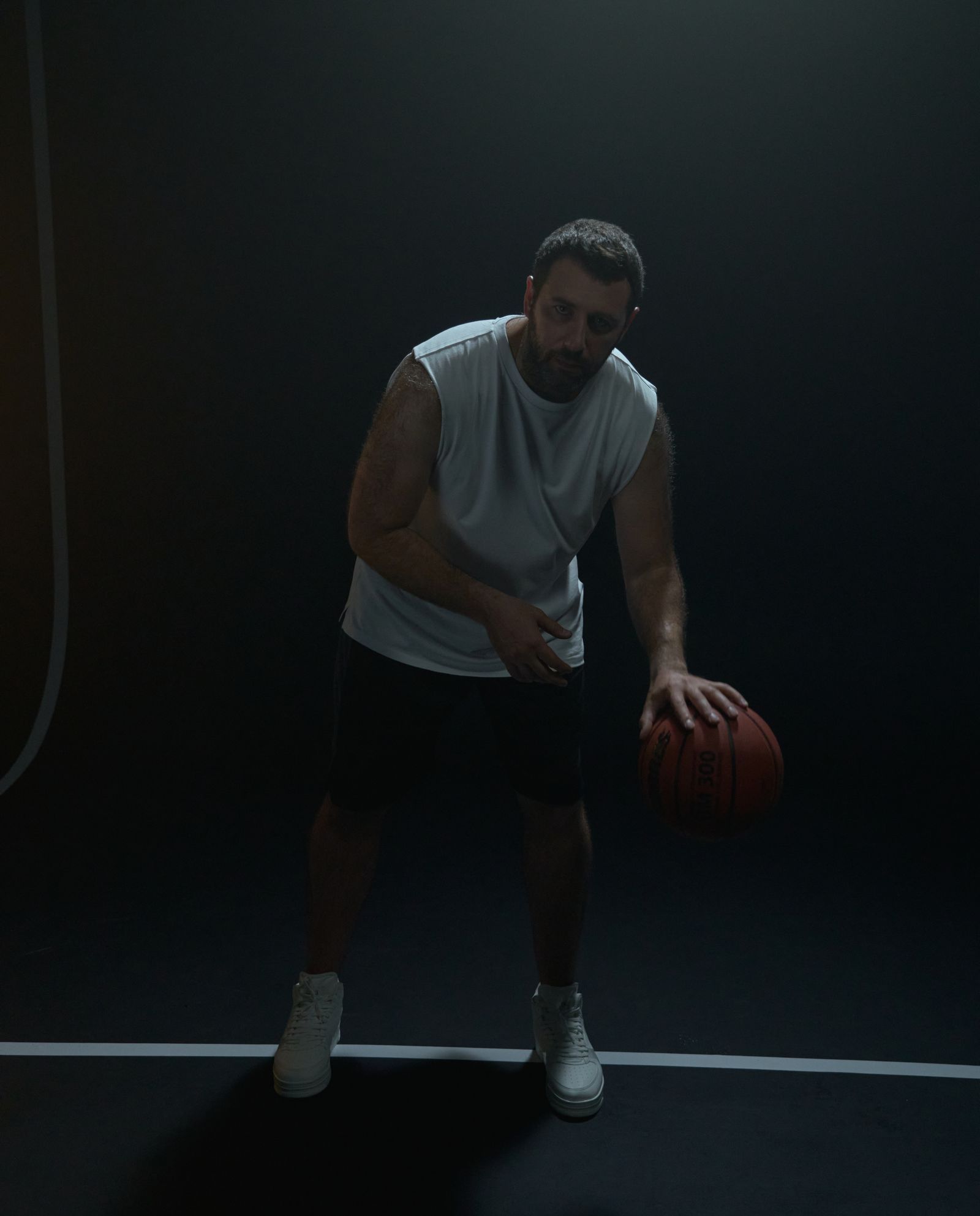 Coach Marcus Hale dribbling on a dark court